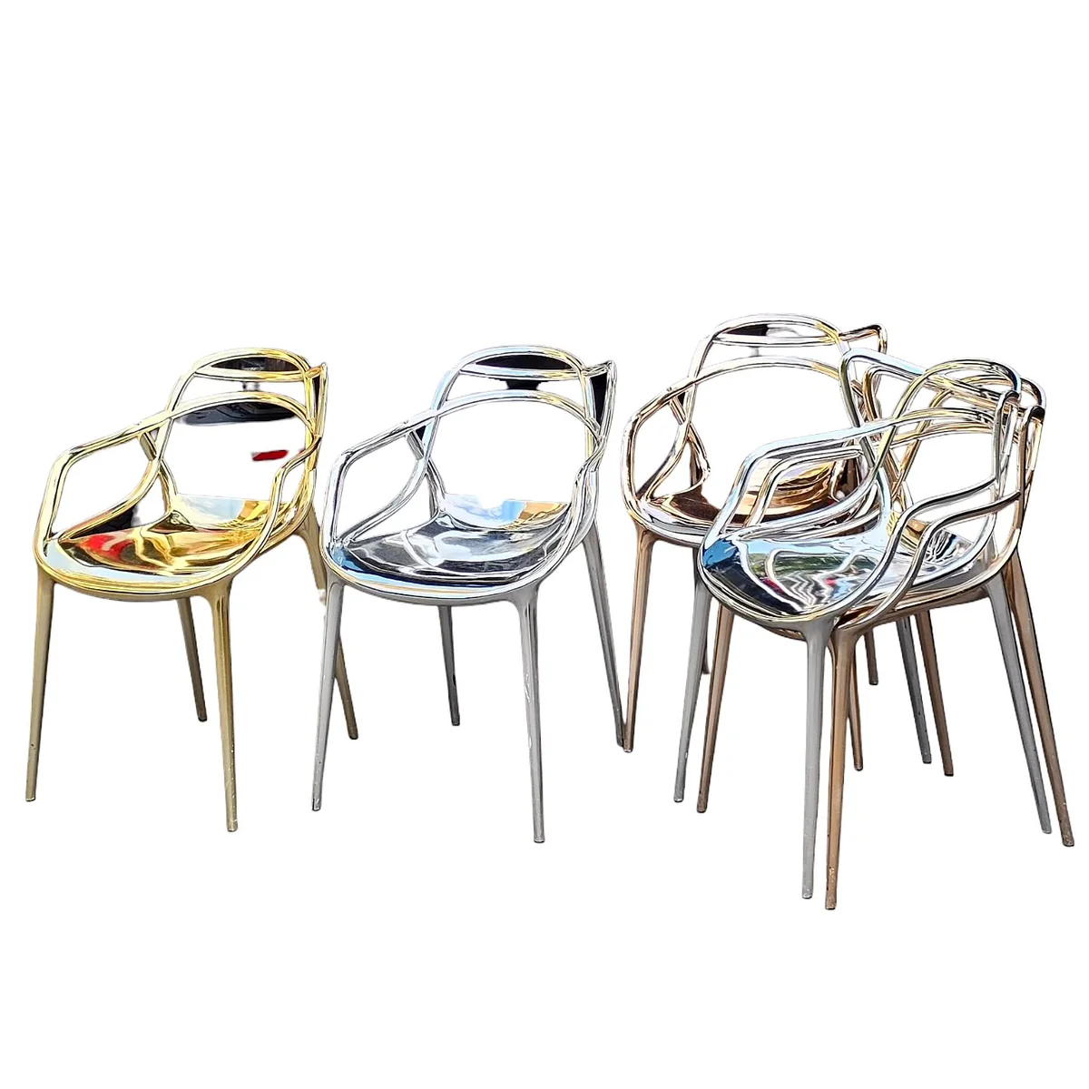 Quatre chaises design aux finitions chromées et dorées, se détachant sur fond blanc.