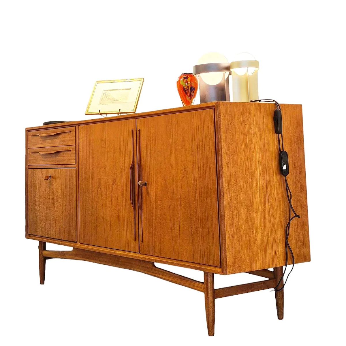 Buffet vintage en bois verni avec deux lampes, un vase et un cadre photo dessus.