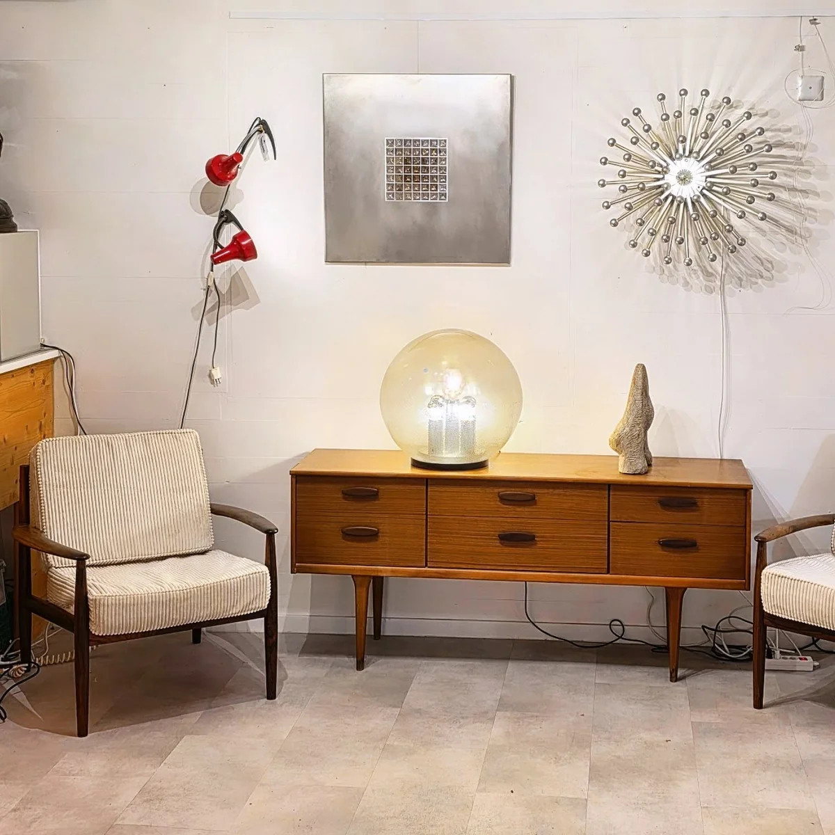 Meuble buffet en bois, chaise et lampe sphérique dans un showroom lumieux.