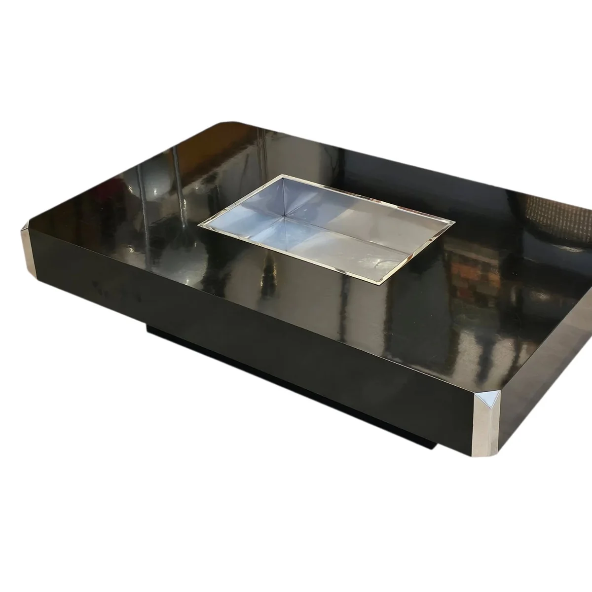 Table basse rectangulaire laquée noire avec un insert central en métal argenté, sur fond blanc.